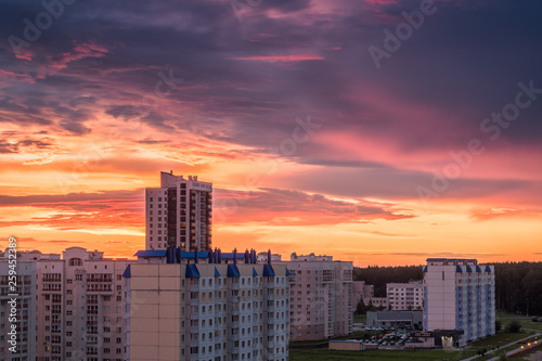 Apartment buildings at sunset. New district on the outskirts of the city at dawn. Bright beautiful orange pink blue sky.