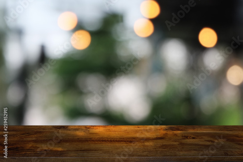 Empty dark wooden table in front of abstract blurred bokeh background of restaurant . can be used for display or montage your products.Mock up for space.