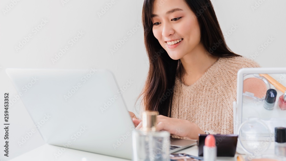 Beautiful asian woman blogger is chatting how to make up and use cosmetics. In front of laptop to recording vlog video live streaming at home.Business online influencer on social media concept. Beautiful asian woman blogger is chatting how to make up and use cosmetics. In front of laptop to recording vlog video live streaming at home.Business online influencer on social media concept.