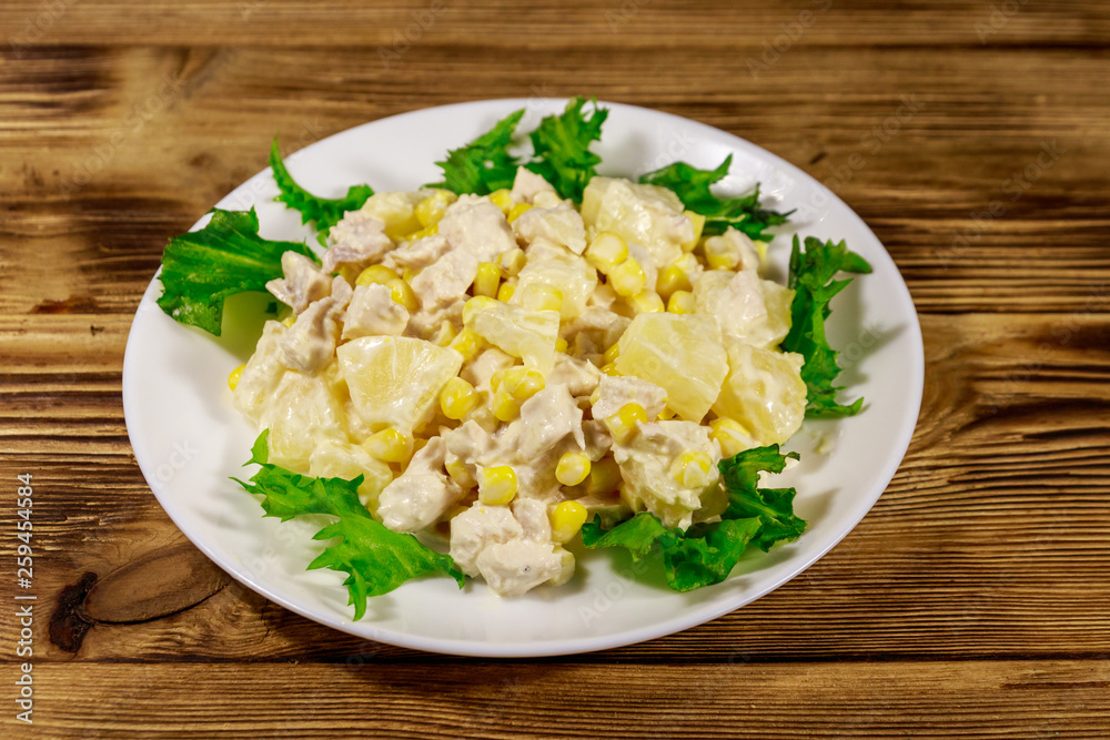 Festive salad with chicken breast, sweet corn, canned pineapple and mayonnaise on wooden table Festive salad with chicken breast, sweet corn, canned pineapple and mayonnaise on wooden table