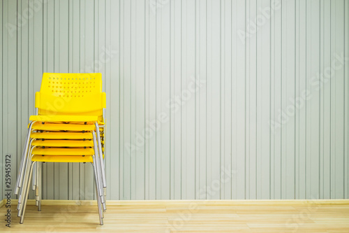 Bilde på lerret Yellow stacking plastic chairs for meeting or workshop in front of gray background