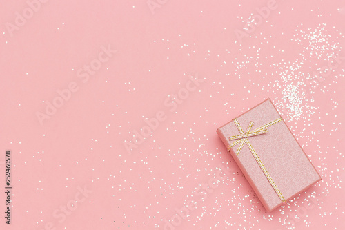 Gift box with bow in corner on pink pastel background in minimal style. Top view Copy space Mockup © IRINA
