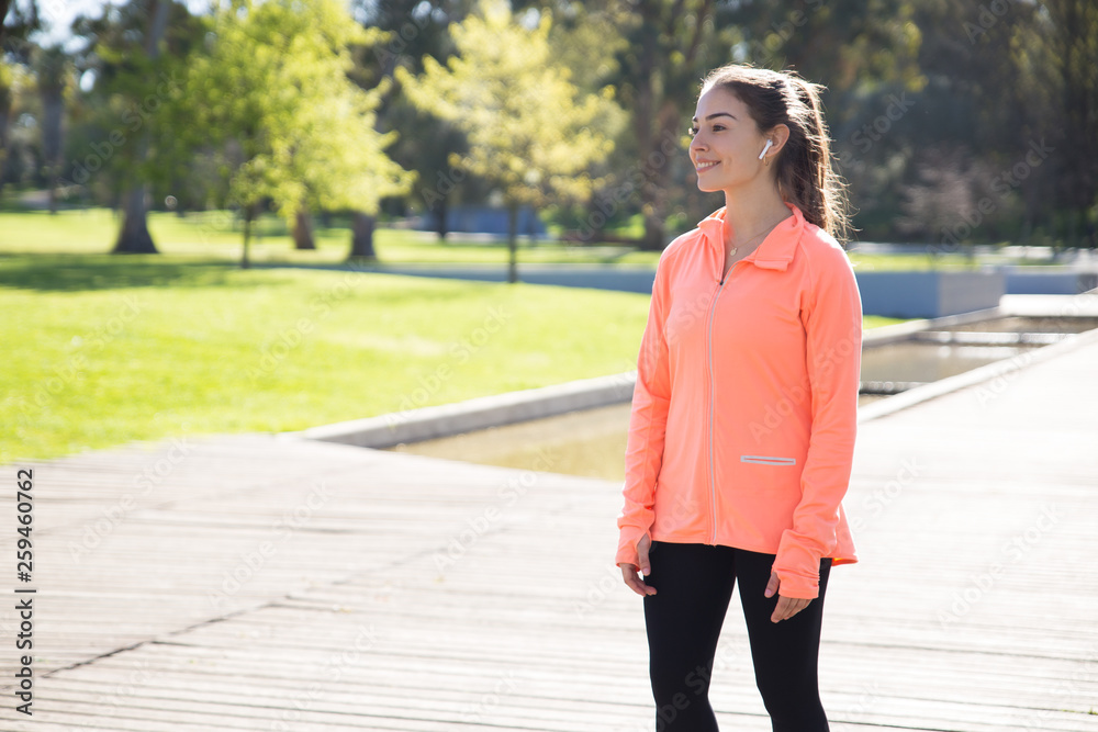Smiling sporty woman relaxing in city park Smiling sporty woman relaxing in city park
