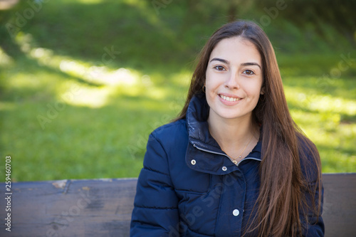 Smiling pretty woman posing at camera in park