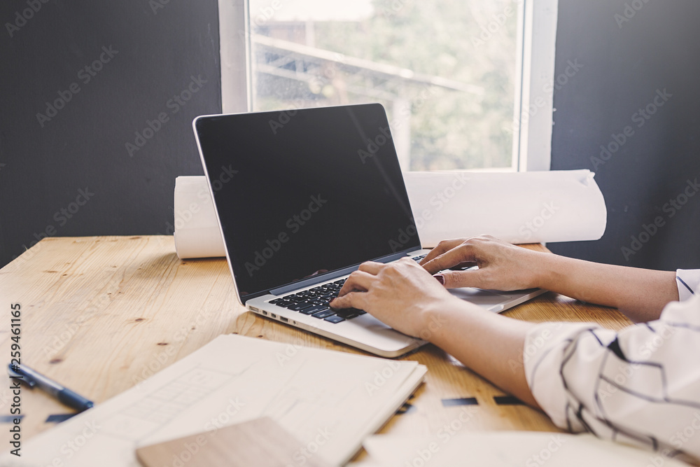 Fototapeta premium Businesspeople discuss a project ;A woman sitting at the computer shows infographics to partners; An example of good relations at work.