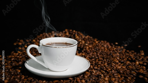 Cup with hot coffee and steam on a dark background