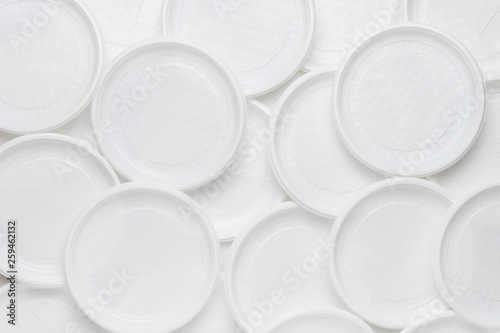 White disposable plastic tableware. Plastic plates. Abstract background of clean white dishes.