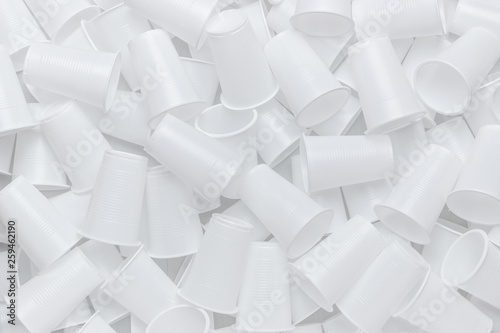 The texture of randomly scattered white disposable plastic cups. Abstract background of plastic dishes. photo