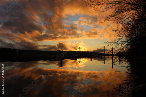 Sunset over the Port Mann Bridge with the Fraser River reflecting the fiery sky Port Coquitlam BC Canada November/20/2017 photo