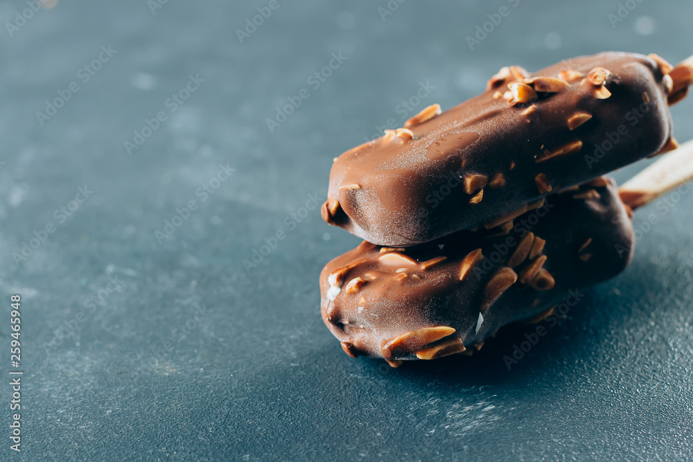 Two portion of Eskimo ice cream in chocolate glaze on blue background. Yummy sweet food snack treat. Copy space