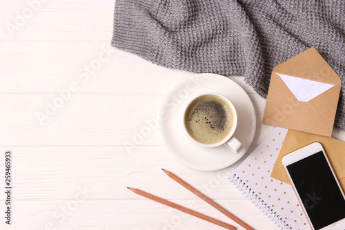 cup of coffee with crema and stationery on wooden background top view.