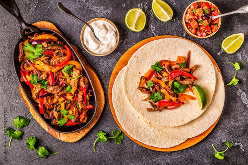 Photos FAJITAS with colored pepper and onions, served with tortillas.