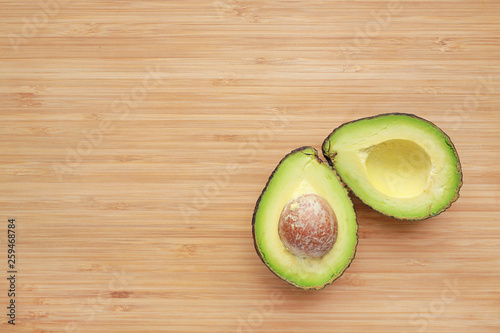 Closeup Avocado cut in half on wooden board background with copy space.