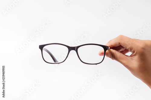 Woman holding the black eye glasses spectacles with shiny black frame isolated on white