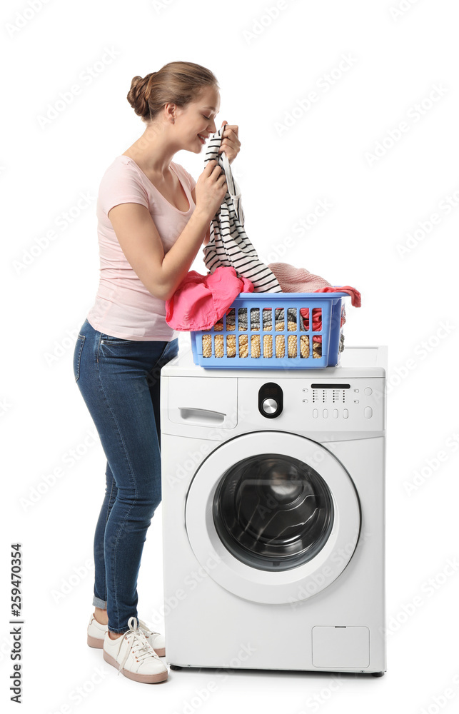 Young woman enjoying smell of clean laundry on white background