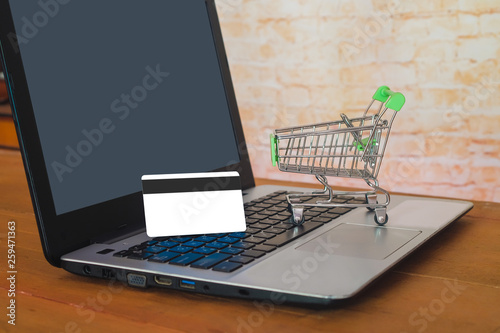 Shopping cart On Laptop Keyboard With Credit Card, Online Shopping Concept .