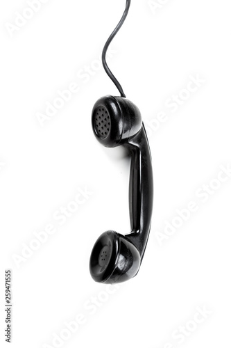 Fotografie old vintage phone handset hanging by the chord isolated over a white background