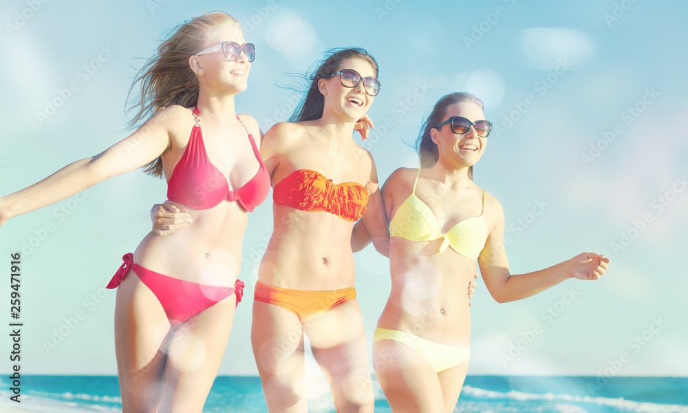 Portrait of three young women friends walking on the sea shore Portrait of three young women friends walking on the sea shore