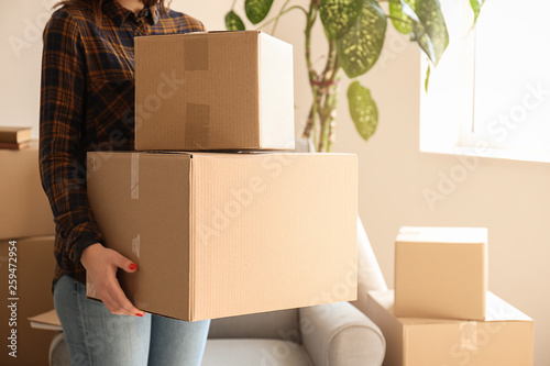 Woman with moving boxes in room