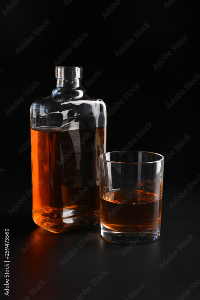 Glass and bottle of whiskey on black background Glass and bottle of whiskey on black background