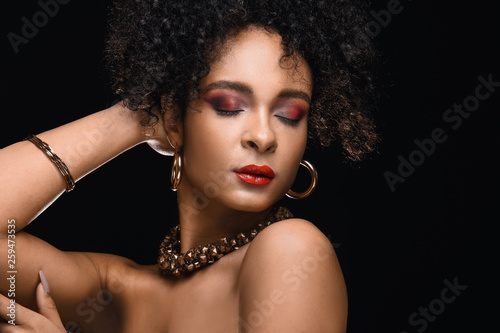 Portrait of beautiful African-American woman on dark background