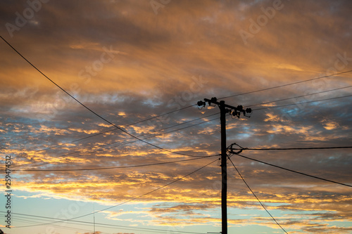 Silhouette of a power lines in Lightning Ridge back lit by a sunset photo