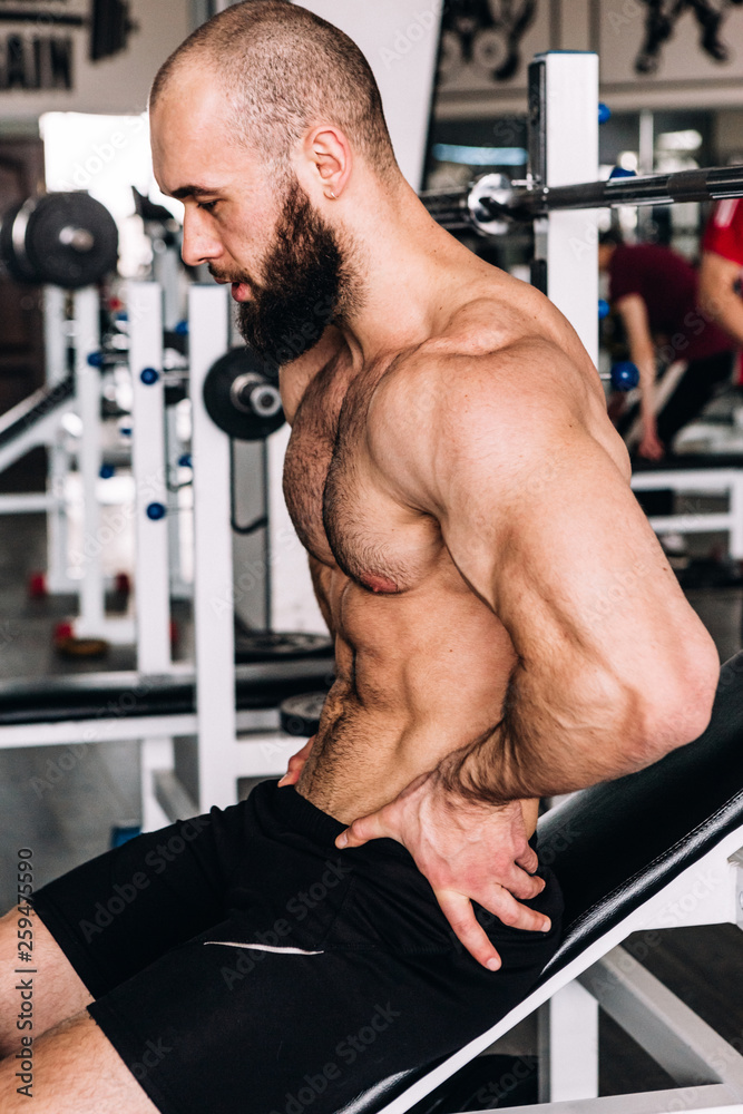 Naklejka premium Muscular guy in the gym