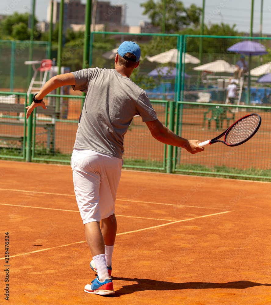 A man plays tennis on the court in the park