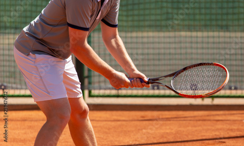 A man plays tennis on the court in the park © schankz
