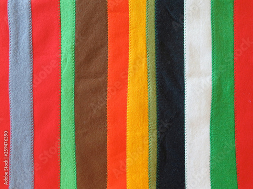 coverlet made of long strips of felt  in different colors sewn together