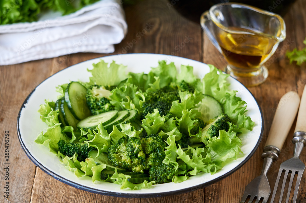 Vegetable salad with broccoli, cucumbers and lettuce in a white bowl Vegetable salad with broccoli, cucumbers and lettuce in a white bowl