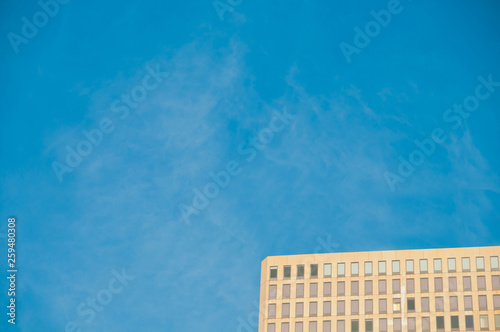 Brown modern high-rise corporate office building with blue sky