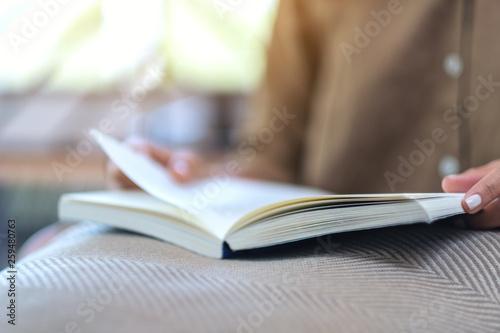 Closeup image of a woman opening and reading a book