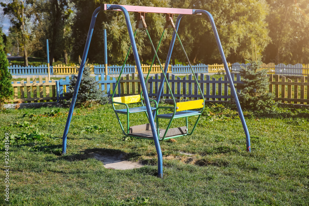 Two swings on children playground. Outdoors games for kids. Summer day. Two swings on children playground. Outdoors games for kids. Summer day.