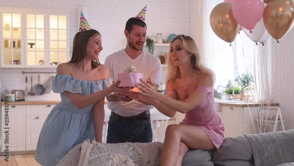 Birthday party of young pretty woman blowing out candles on birthday cake