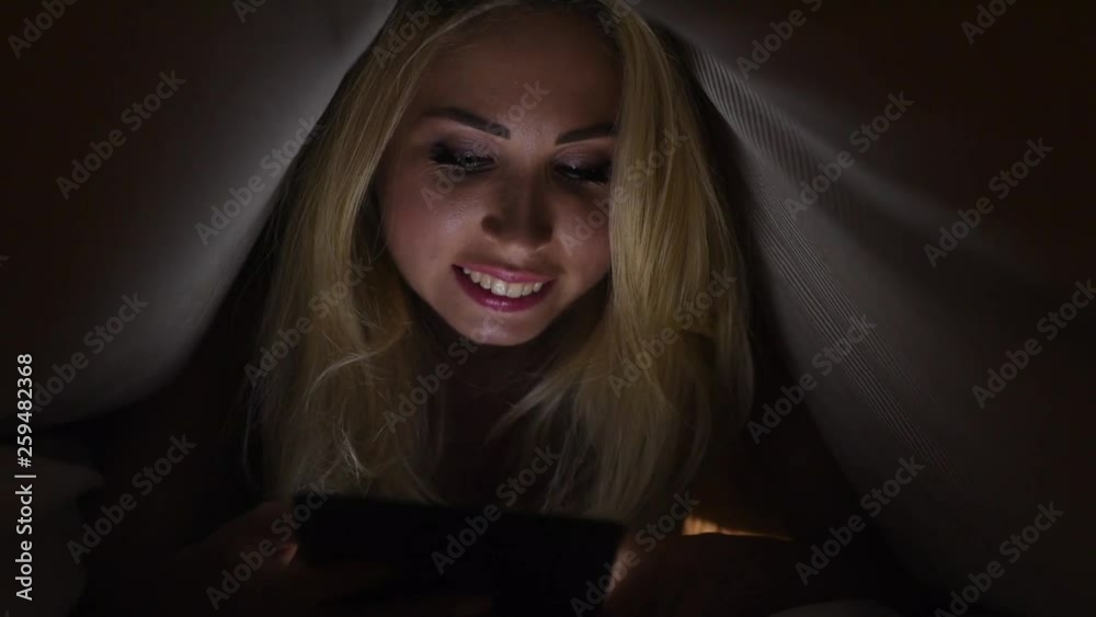custom made wallpaper toronto digitalCheerful young girl lying under blanket and typing on mobile phone in bed