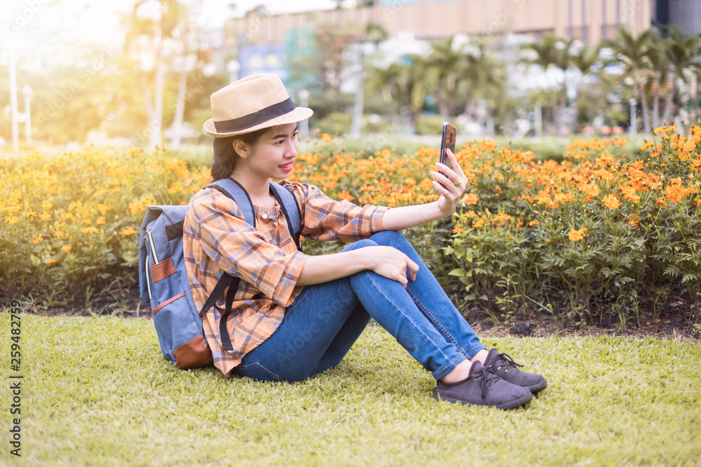 Asian women tourists are taking and selfie photos with a smartphone at flowers garden. traveling in the holidays. Asian women tourists are taking and selfie photos with a smartphone at flowers garden. traveling in the holidays.