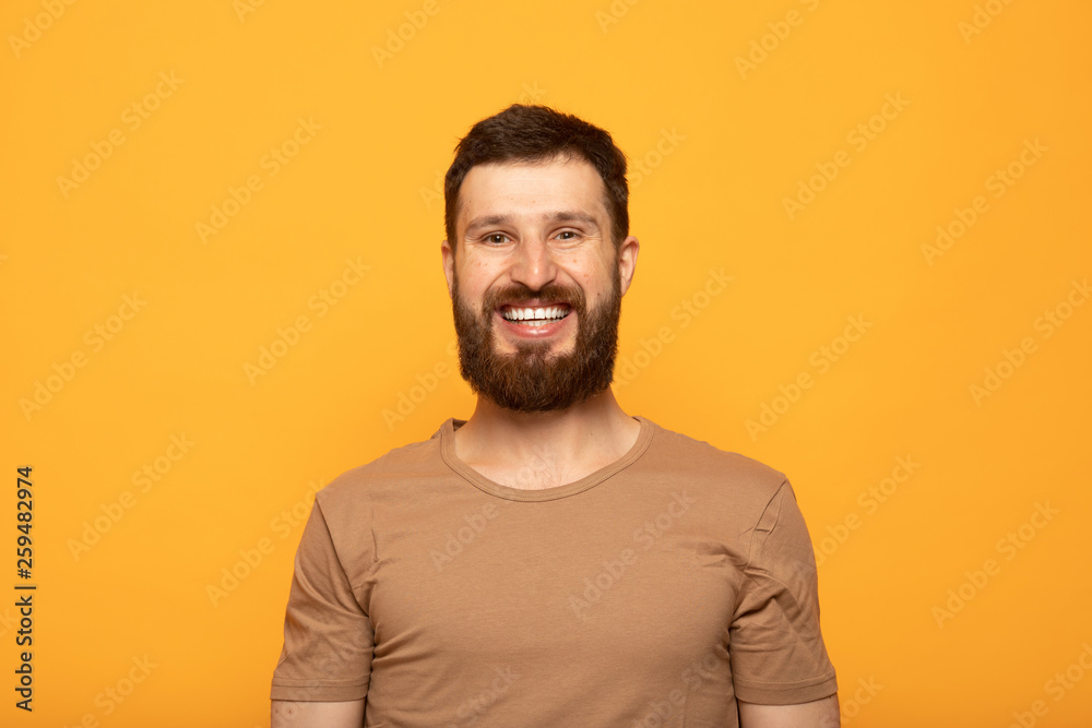 Horizontal close up portrait of a man with beard laughing on isolated color background Horizontal close up portrait of a man with beard laughing on isolated color background