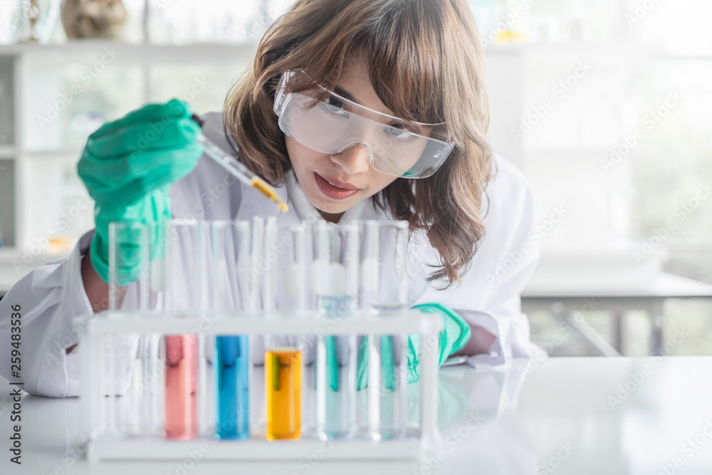 A young Asian woman scientist working in laboratory with test tube microscope and solutions. A young Asian woman scientist working in laboratory with test tube microscope and solutions.