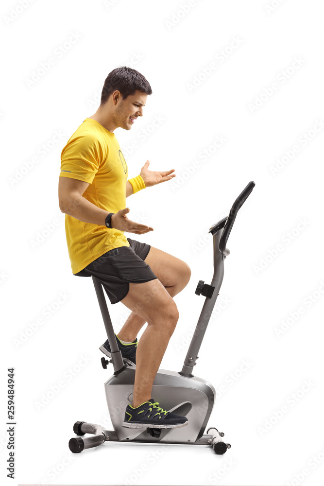 Young dissatisfied man on a stationary bike Young dissatisfied man on a stationary bike