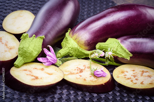  Eggplant bloom. Healthy eating concept. Fresh sliced eggplant. Eggplant close up. Slices of eggplant with greens.