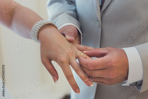Young bride and groom exchange rings during the wedding.