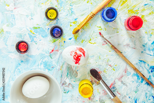 brushes, paints, the eggs on an art table made for painting of Easter egg, the top view