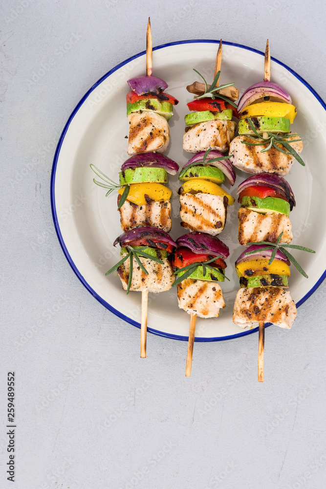 Chicken skewers kebob grilled with vegetables in a plate serving.