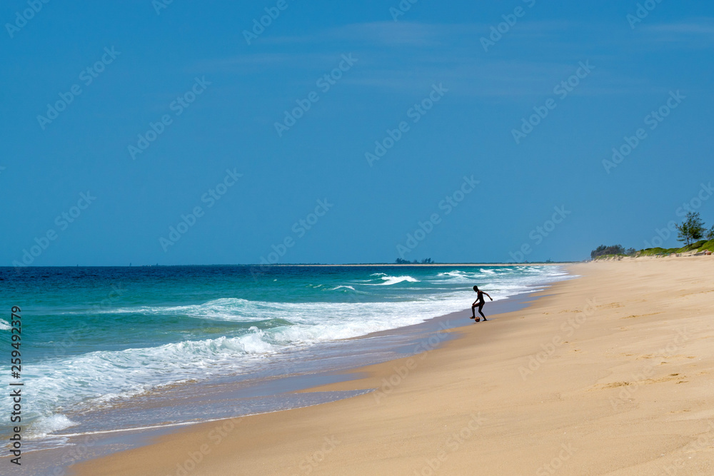 boy playing ball on the beach Indian Ocean Mozambique Africa