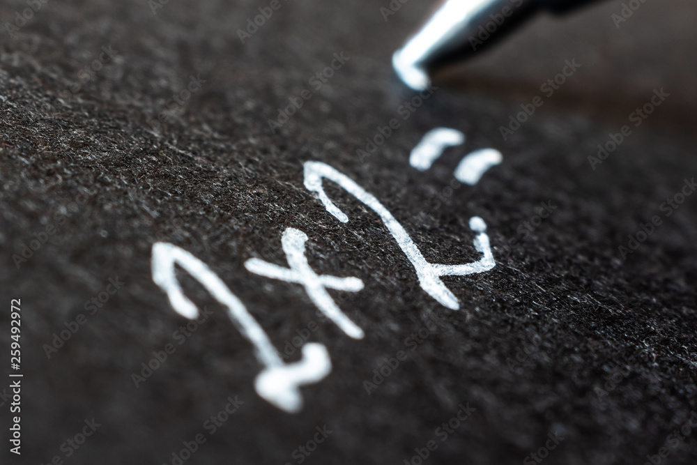 Fototapeta premium Handwritten white lettering on black paper, photographed close-up. Macro photo suitable for background.