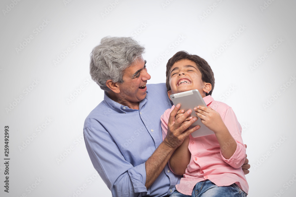 Grandfather and grandson using digital tablet Grandfather and grandson using digital tablet