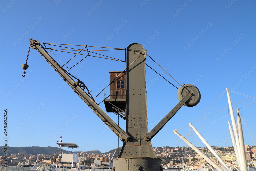 An old crane for loading cargo ships inside the ancient port of Genoa An old crane for loading cargo ships inside the ancient port of Genoa