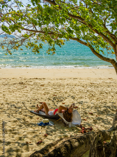 Fototapeta Naklejka Na Ścianę i Meble -  Woman enjoying her holidays on a transat at the tropical beach