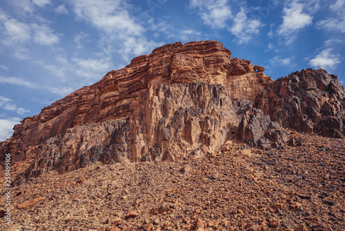 Rocky mountain seen from a path to so called Lawrence Spring in famous Wadi Rum - Valley of Sand in southern Jordan